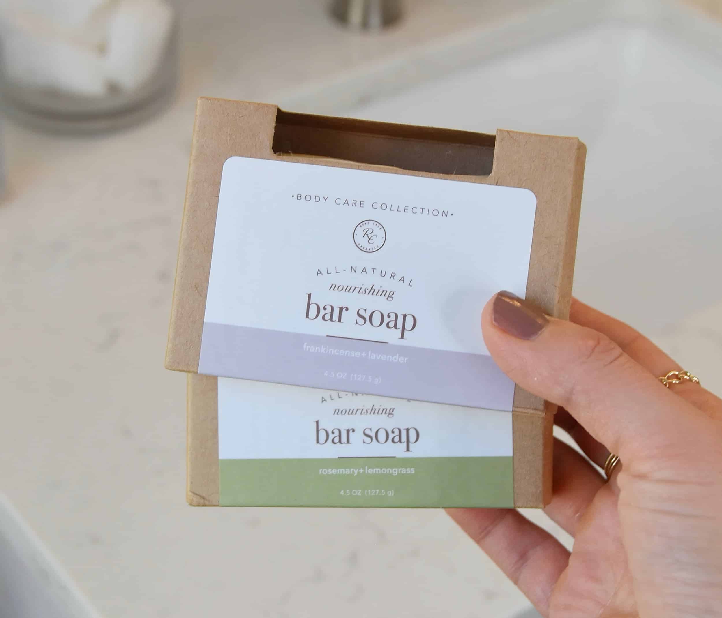 Holding two packages of Rowe Casa Organics Bar Soap for review.
